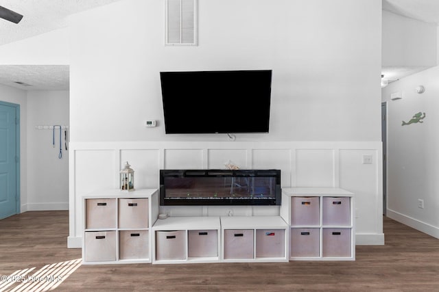 living room with lofted ceiling, hardwood / wood-style floors, and a textured ceiling