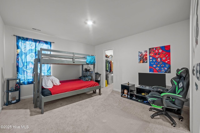 carpeted bedroom with a walk in closet, baseboards, visible vents, and a closet