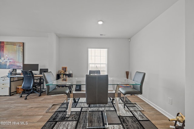 dining room with visible vents, baseboards, and light wood finished floors