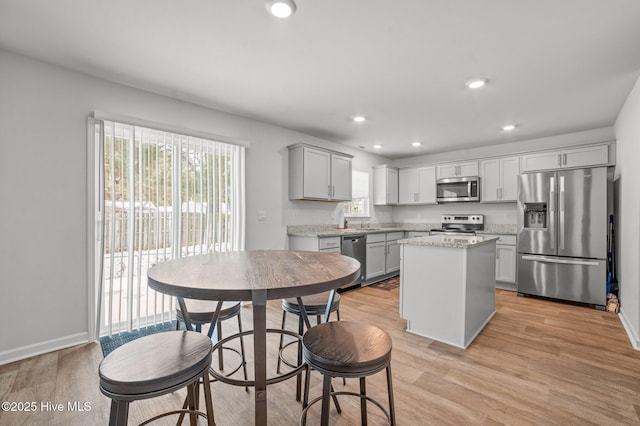 kitchen with stainless steel appliances, light wood-style floors, a healthy amount of sunlight, and gray cabinets