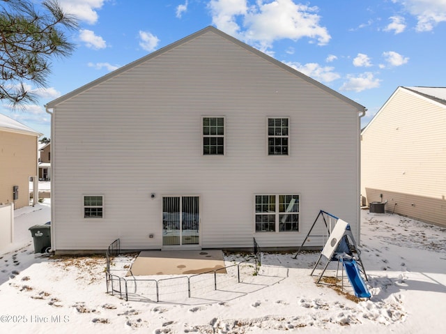 snow covered rear of property featuring a patio area