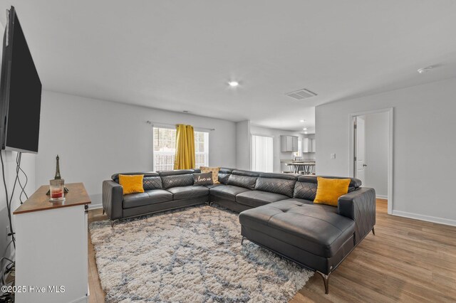 living area with recessed lighting, visible vents, baseboards, and light wood-style flooring