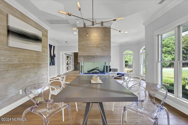 dining space featuring crown molding, baseboards, recessed lighting, and wooden walls