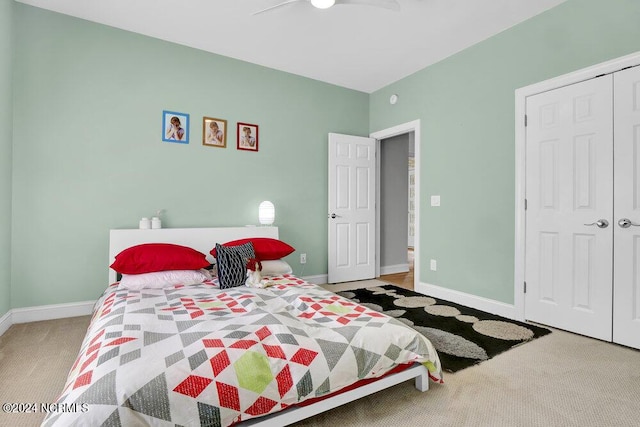 bedroom with a closet, baseboards, a ceiling fan, and carpet flooring