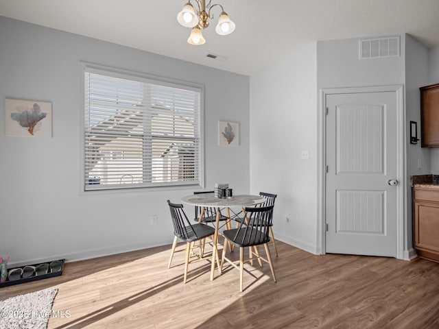 dining area featuring hardwood / wood-style flooring and a notable chandelier