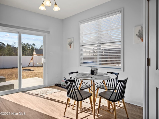 dining space featuring hardwood / wood-style flooring and a notable chandelier