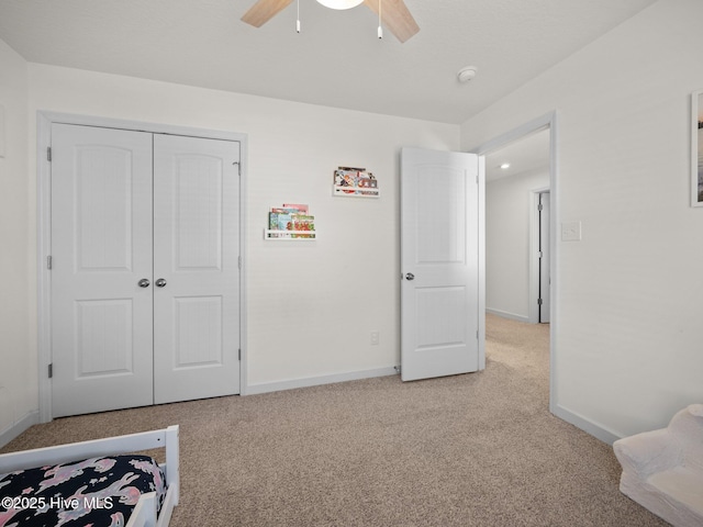 carpeted bedroom featuring ceiling fan and a closet