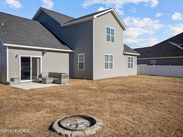 back of property featuring a patio, a fire pit, and a lawn