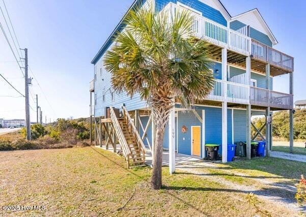 rear view of house with a balcony and a lawn