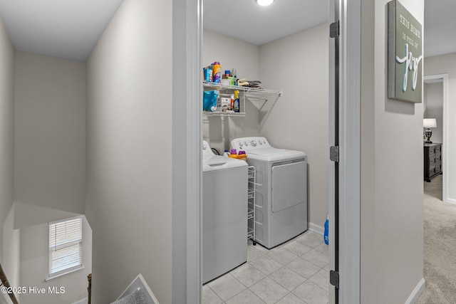 clothes washing area with light tile patterned floors and independent washer and dryer