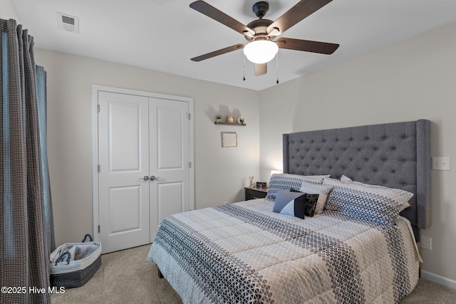 carpeted bedroom featuring ceiling fan and a closet