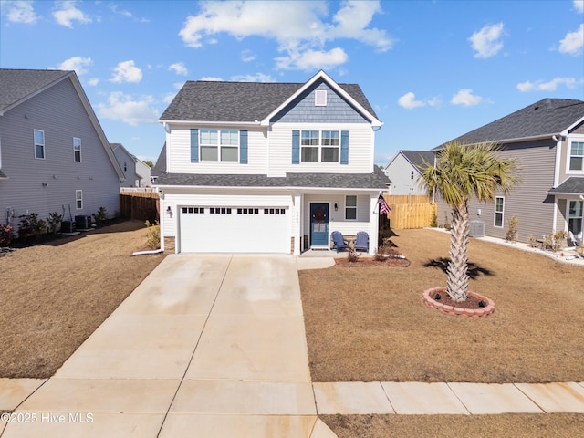 view of front of property featuring cooling unit, a garage, and a front yard