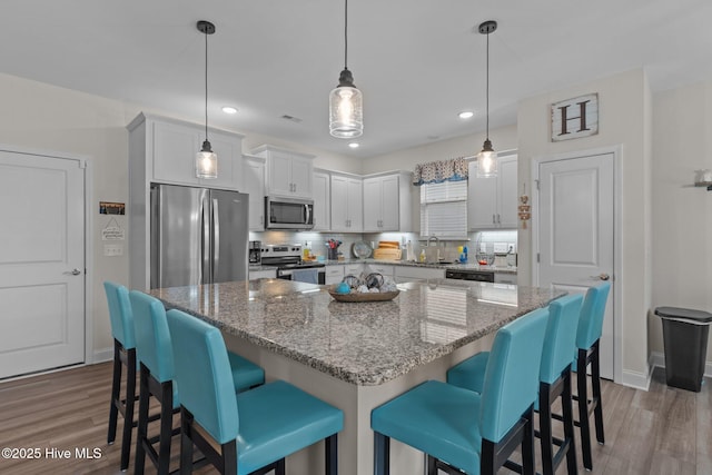 kitchen featuring white cabinetry, stainless steel appliances, and a kitchen island