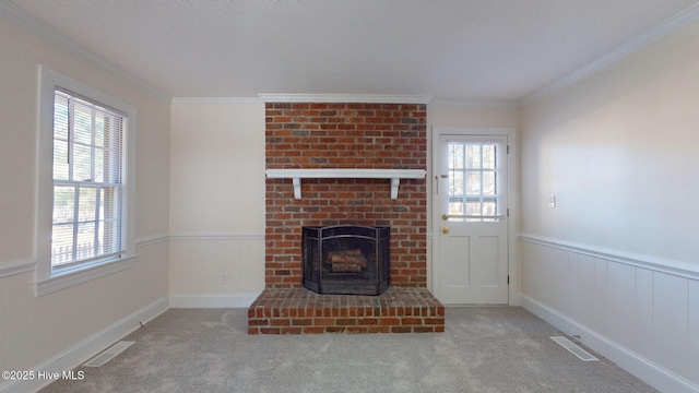 unfurnished living room with crown molding, a fireplace, light colored carpet, and a textured ceiling