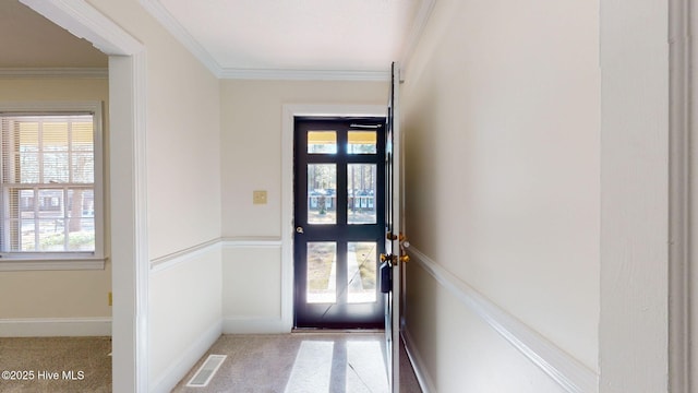 doorway featuring ornamental molding, a healthy amount of sunlight, and light carpet