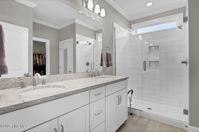 bathroom featuring a shower with door, crown molding, and vanity