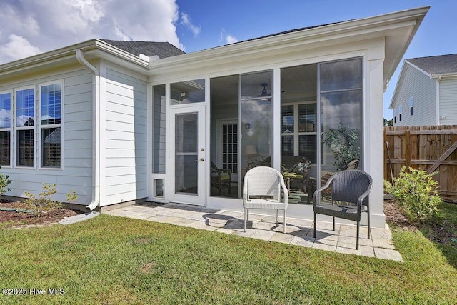 rear view of house with a yard, a patio area, and a sunroom