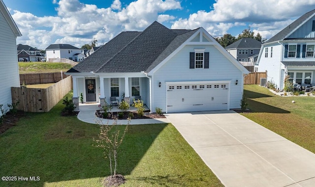 view of front of property with a garage, a front yard, and covered porch