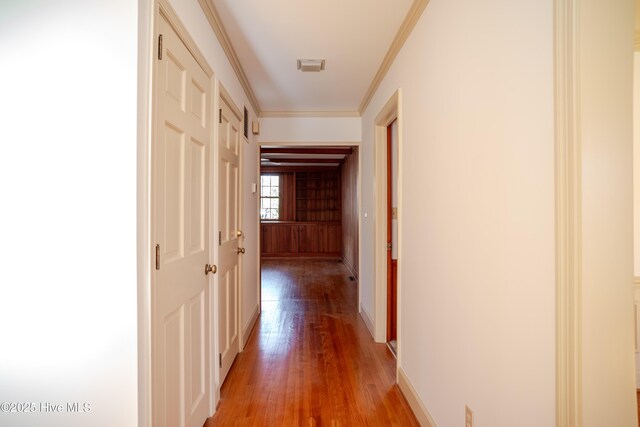 hall with hardwood / wood-style flooring and crown molding