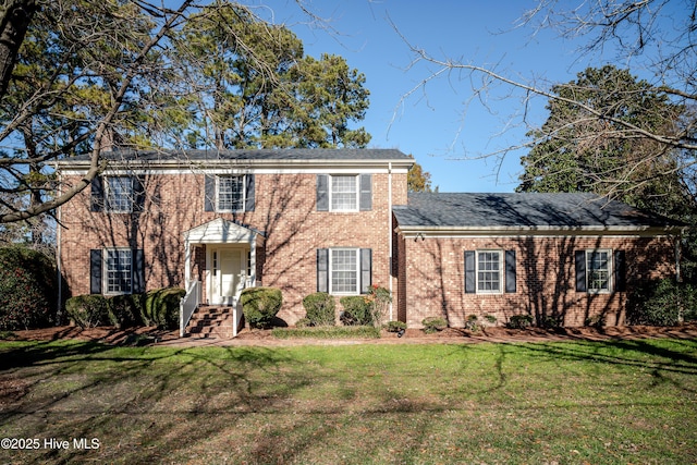 colonial inspired home featuring a front lawn