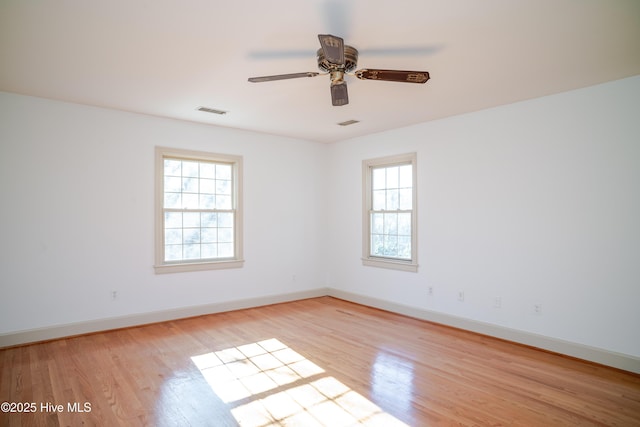 empty room with ceiling fan and light hardwood / wood-style flooring