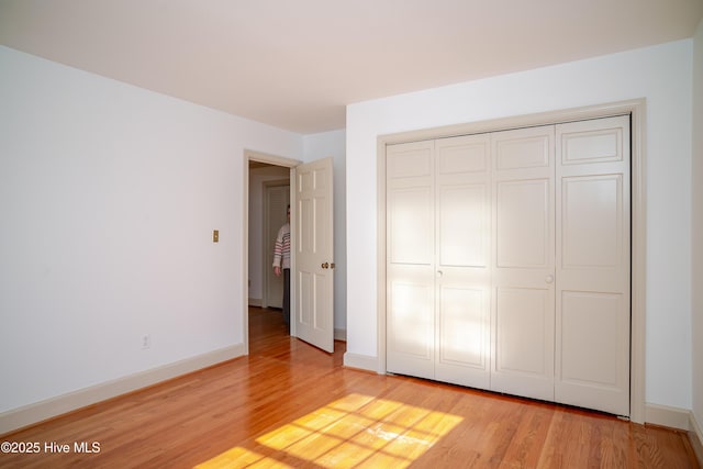 unfurnished bedroom featuring a closet and light hardwood / wood-style flooring