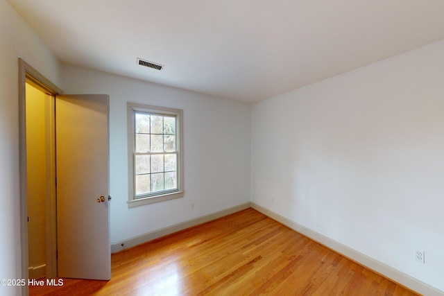 unfurnished room with hardwood / wood-style flooring