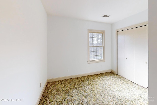 unfurnished bedroom with carpet flooring and a closet