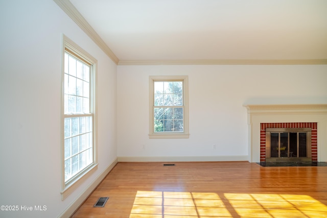 unfurnished living room with hardwood / wood-style floors, a fireplace, and ornamental molding