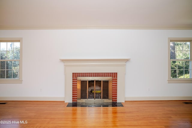 details featuring crown molding, a brick fireplace, and wood-type flooring