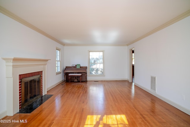 unfurnished living room featuring crown molding, a fireplace, and wood-type flooring