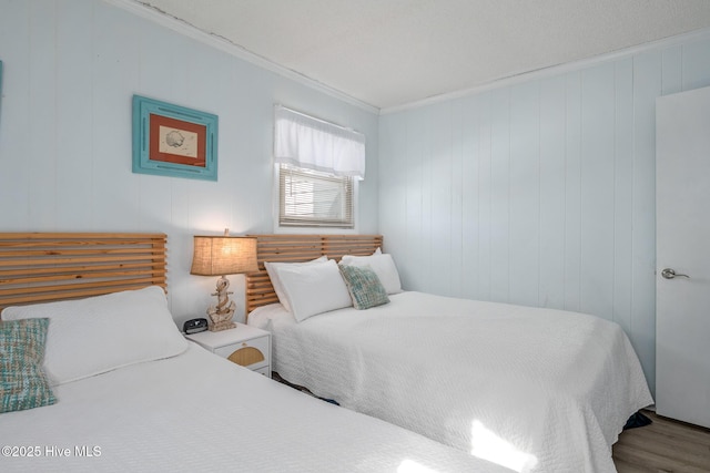 bedroom with ornamental molding and wood-type flooring