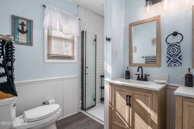 bathroom featuring hardwood / wood-style flooring, vanity, an enclosed shower, and toilet