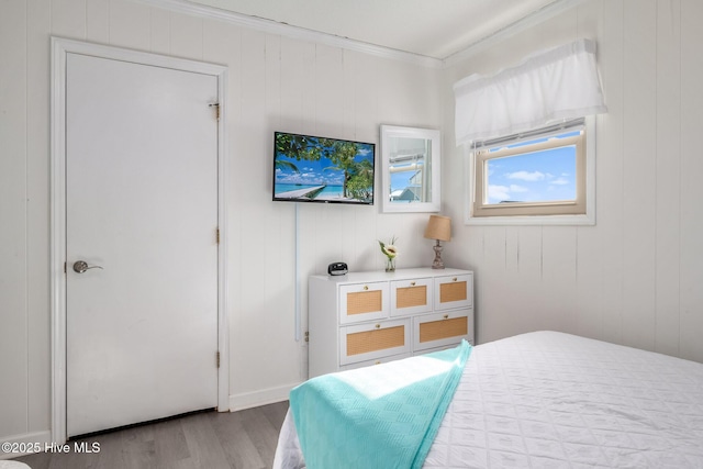 bedroom with crown molding and light hardwood / wood-style floors