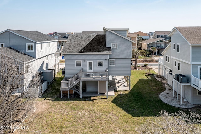 rear view of property featuring cooling unit, a wooden deck, and a lawn