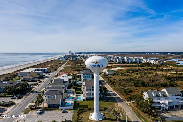 birds eye view of property with a water view and a beach view