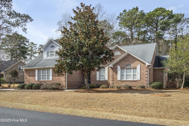 view of front of home with brick siding and a front yard