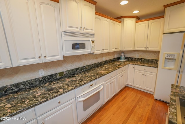 kitchen featuring light wood-style floors, white appliances, white cabinetry, and decorative backsplash