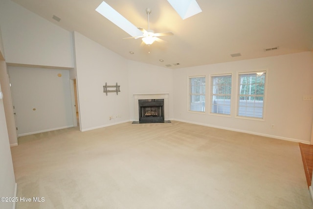 unfurnished living room featuring light carpet, vaulted ceiling with skylight, a premium fireplace, and baseboards