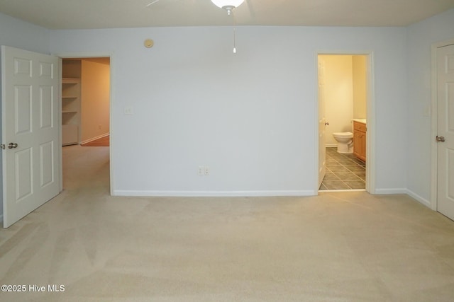 unfurnished room featuring light carpet and baseboards