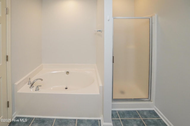 full bath featuring a stall shower, tile patterned flooring, baseboards, and a bath