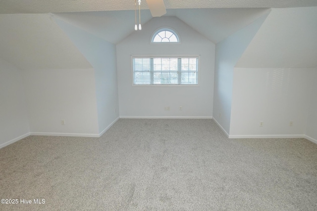 bonus room with light carpet, baseboards, and vaulted ceiling