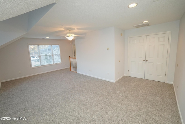 interior space with baseboards, visible vents, light colored carpet, a textured ceiling, and recessed lighting