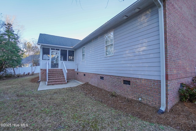 rear view of house with a sunroom, crawl space, roof with shingles, and fence