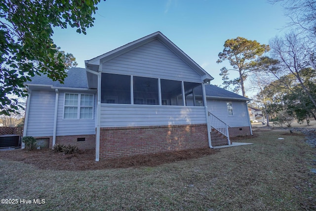 rear view of property with a yard, a shingled roof, central AC unit, a sunroom, and crawl space