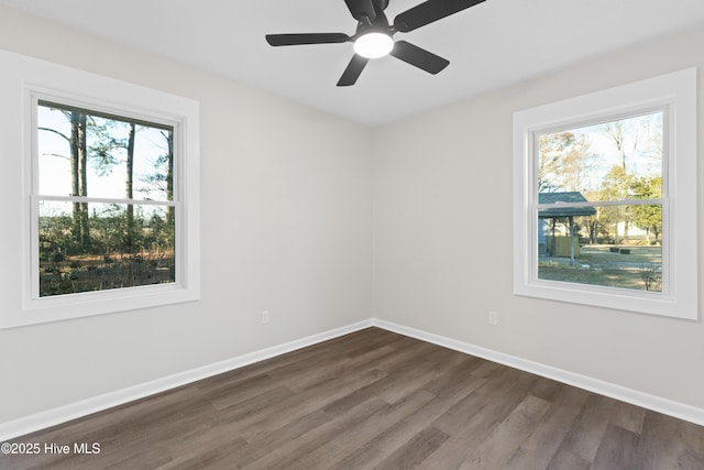 empty room with dark wood-type flooring and ceiling fan