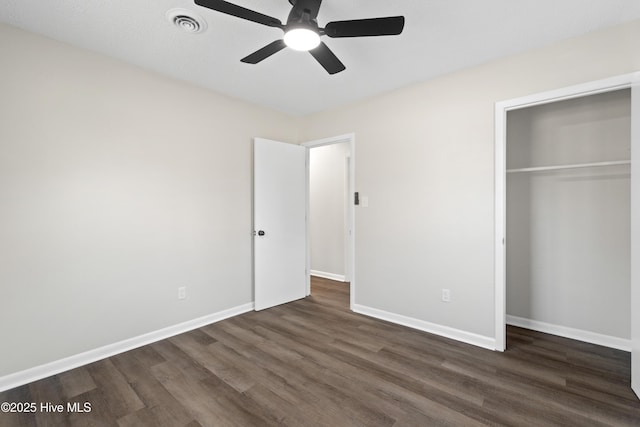 unfurnished bedroom with ceiling fan, dark hardwood / wood-style floors, and a closet