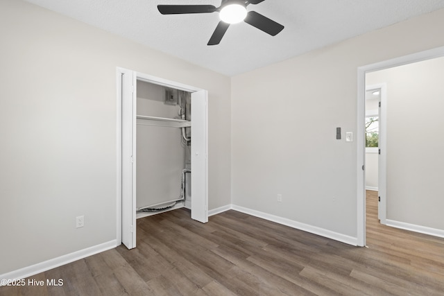 unfurnished bedroom with wood-type flooring, ceiling fan, and a closet