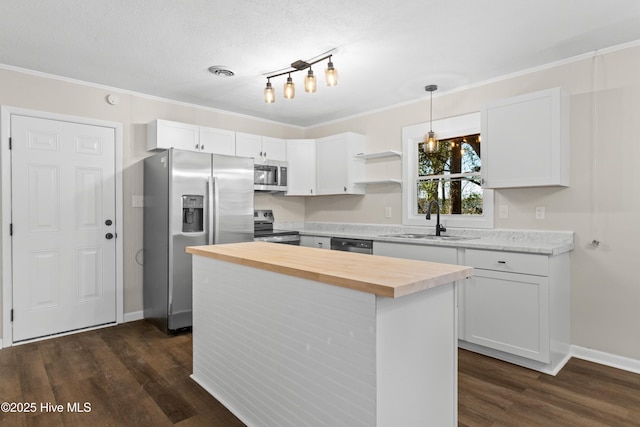 kitchen with decorative light fixtures, white cabinetry, sink, a center island, and stainless steel appliances