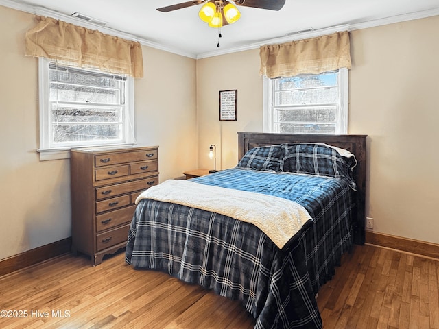 bedroom featuring crown molding, hardwood / wood-style flooring, and ceiling fan